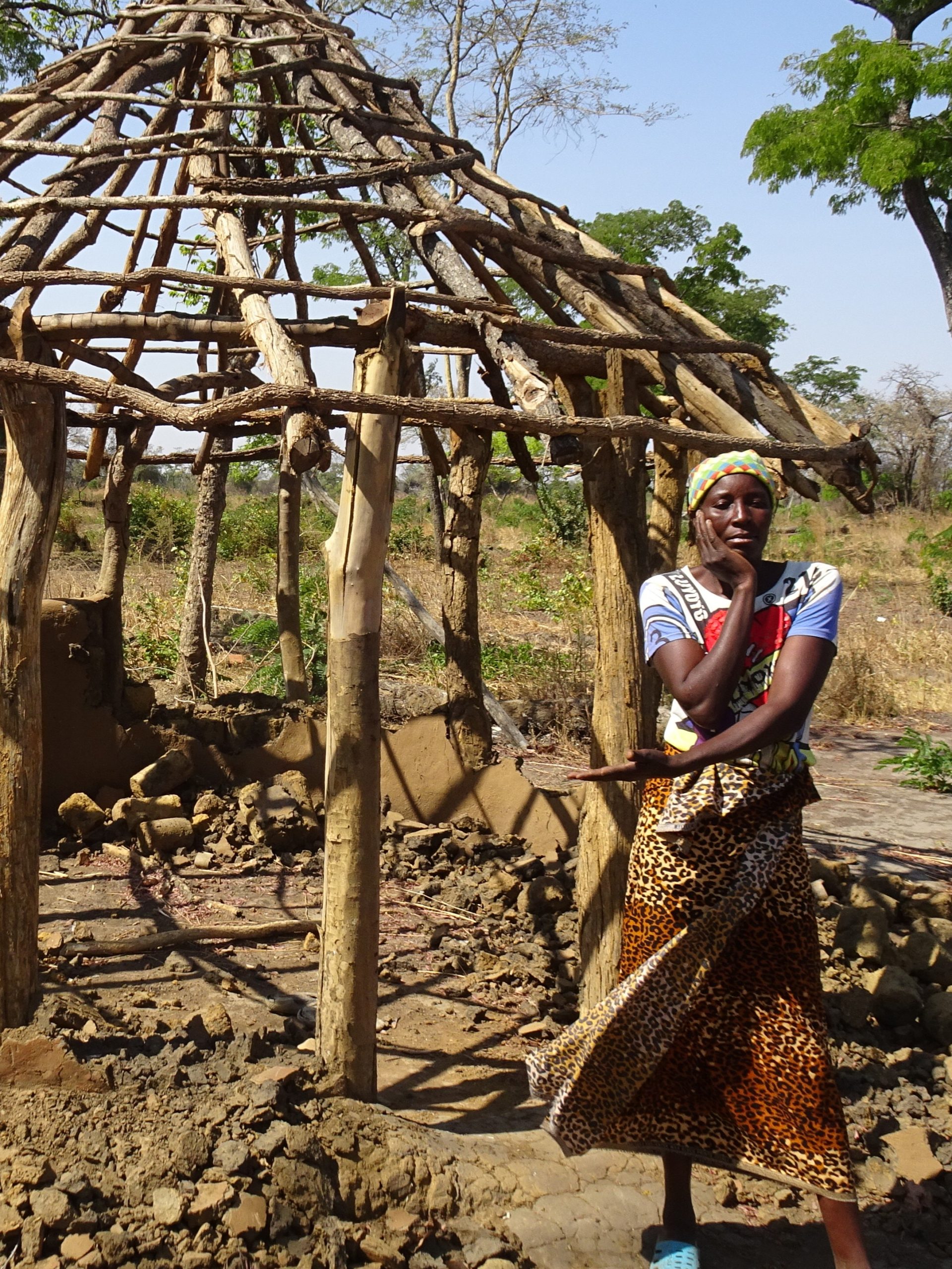 Ester vor ihrem zerstörten Haus in Sambia